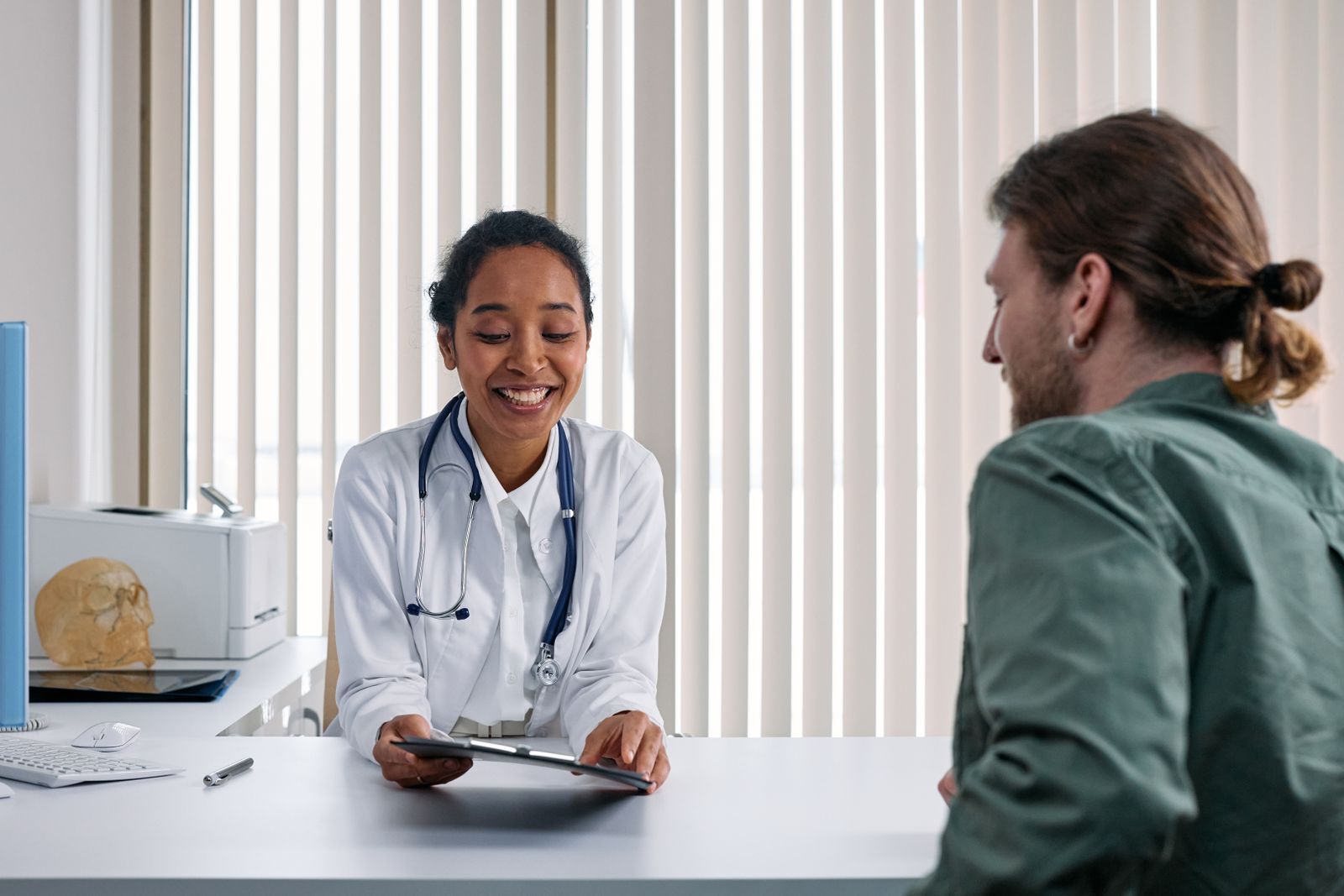 A doctor speaking with a patient in a bright consultation room
